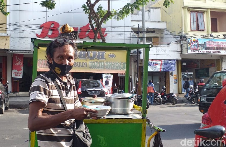 Jago Bahasa Jepang, Penjual Bubur di Surabaya Minder Pakai KemampuannyaAmir BaihaqiSurabaya - Faiz Tosal (53), seorang pejual bubur kacang ijo yang fasih berbahasa Jepang di Surabaya videonya viral di medsos. Meski begitu, Faiz mengaku jarang menggunakan saat melayani para pelanggannya.