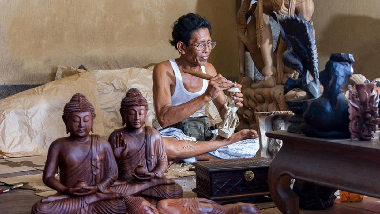 Perajin di Bali A man is making wooden crafts in Indonesia