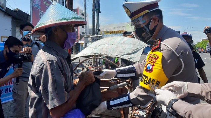 Di HUT Lalu Lintas ke-65, polisi Ngawi membagikan masker dan sembako. Para tukang becak yang terdampak pandemi COVID-19 mengaku senang.