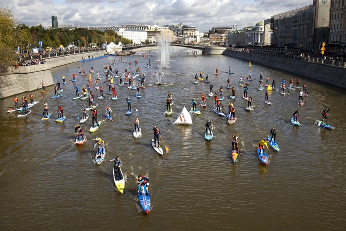 People steer their SUP boards along the Moscow River Channel during a SUP (Stand Up Paddle)-Surfing festival in Moscow, Russia, Saturday, Sept. 19, 2020. (AP Photo/Alexander Zemlianichenko)