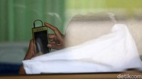 Ada juga yang tiduran sambil bermain handphone saat menjalani isolasi di stadion tersebut.