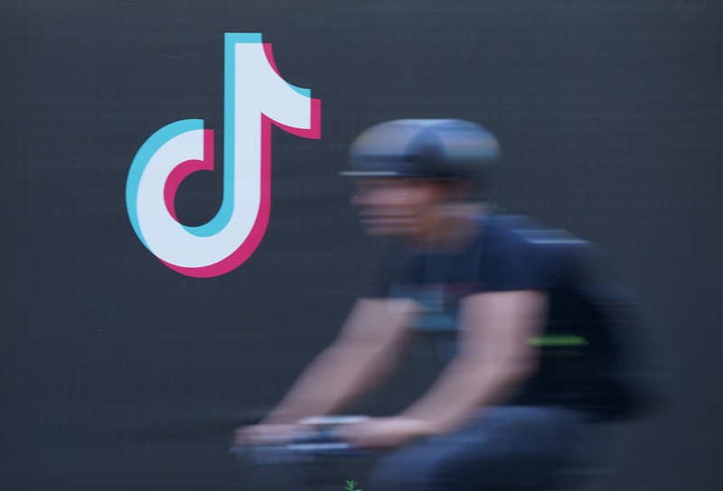 BERLIN, GERMANY - SEPTEMBER 21: A young man holding a smartphone casts a shadow as he walks past an advertisement for social media company TikTok on September 21, 2020 in Berlin, Germany. U.S. President Donald Trump has given preliminary approval for Oracle, Walmart and other investors to take over TikTok and create a new U.S.-based company called TikTok Global. (Photo by Sean Gallup/Getty Images)