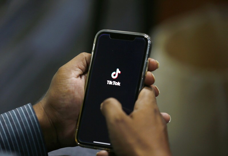 FILE - In this July 21, 2020 file photo, a man opens social media app 'TikTok' on his cell phone, in Islamabad, Pakistan. President Donald Trump said Saturday, Sept. 19, 2020 he’s given his “blessing” to a proposed deal between Oracle and Walmart for the U.S. operations of TikTok, the Chinese-owned app he’s targeted for national security and data privacy concerns. (AP Photo/Anjum Naveed, File)