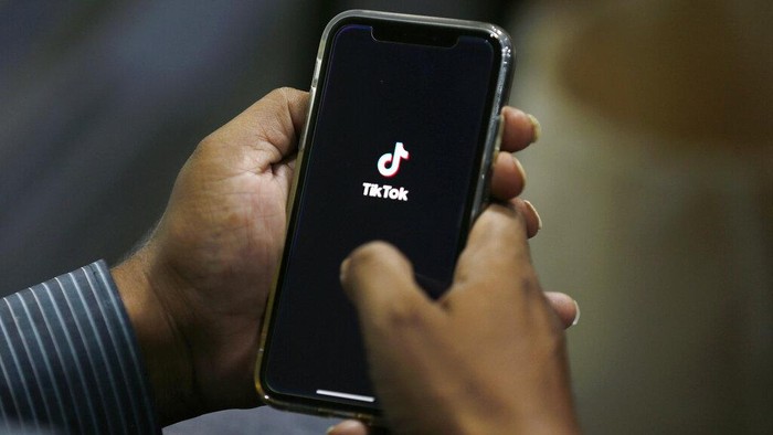 FILE - In this July 21, 2020 file photo, a man opens social media app TikTok on his cell phone, in Islamabad, Pakistan. President Donald Trump said Saturday, Sept. 19, 2020 he’s given his “blessing” to a proposed deal between Oracle and Walmart for the U.S. operations of TikTok, the Chinese-owned app he’s targeted for national security and data privacy concerns. (AP Photo/Anjum Naveed, File)