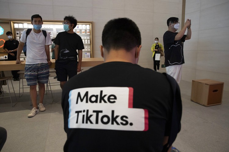US QA TikTok Oracle FILE - In this July 17, 2020, file photo, a man wearing a shirt promoting TikTok is seen at an Apple store in Beijing, China. TikTok’s parent company ByteDance has chosen Oracle over Microsoft as a new American technology partner to help keep the popular video-sharing app operating in the U.S., according to a person familiar with the deal.(AP Photo/Ng Han Guan, File)