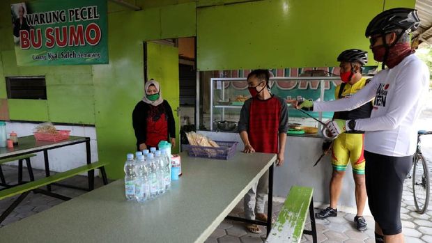 Gubernur Jawa Tengah, Ganjar Pranowo, memasang lakban jaga jarak di sejumlah bangku warung makan di kawasan Semarang. Hal itu dilakukan untuk cegah Corona.