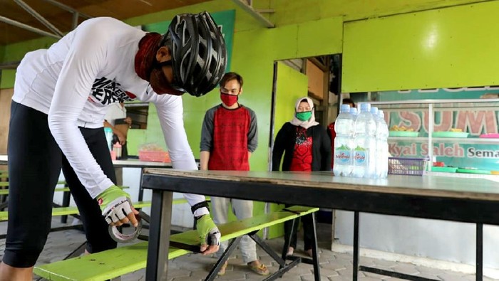 Cegah Corona, Ganjar Pasang Lakban di Bangku Warung Makan Semarang Gubernur Jawa Tengah, Ganjar Pranowo, memasang lakban jaga jarak di sejumlah bangku warung makan di kawasan Semarang. Hal itu dilakukan untuk cegah Corona.