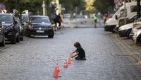 Tak hanya menggambar, seorang anak juga tampak asyik bermain menyusun traffic cone mini di tengah jalan yang ditutup untuk memperingati Hari Bebas Kendaraan Internasional.
