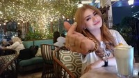 Berpose dengan jari membentuk simbol hati, ini pose cantik dari Nathalie Holscher saat di kafe bertabur gemerlap lampu. Tak lupa minuman segar yang ia pesan. Foto: Nathalie Holscher