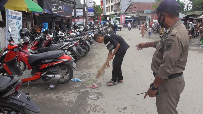 Pelanggar protokol kesehatan disanksi sosial menyapu jalan pasar