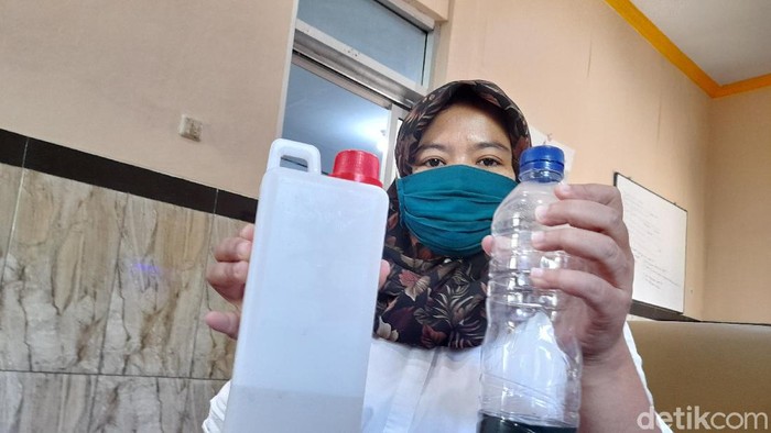 Petugas menunjukkan hasil air sumur warga yang sempat bikin heboh karena mengeluarkan BBM yang kini mulai jernih