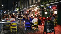 Orang-orang makan dan minum di luar restoran di Soho, London, Inggris. AP Photo/Alberto Pezzali  