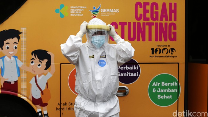 Tenaga medis mendampingi orang tanpa gejala (OTG) menaiki bus sekolah di Puskesmas Kecamatan Jatinegara, Jakarta, Kamis (24/9/2020). Sejumlah unit bus sekolah kini dialihfungsikan menjadi kendaraan untuk mengantar pasien Covid-19 berstatus OTG dari puskesmas ke RS Darurat Wisma Atlet seiring meningkatnya kasus baru virus corona di Jakarta.