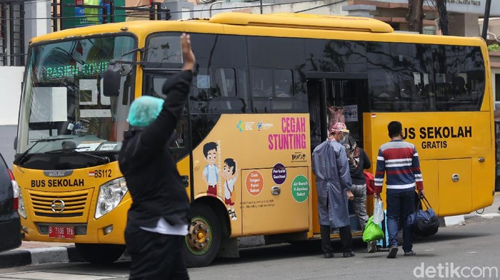 Bus Sekolah Digunakan Untuk Jemput Pasien COVID-19 Tenaga medis mendampingi orang tanpa gejala (OTG) menaiki bus sekolah di Puskesmas Kecamatan Jatinegara, Jakarta, Kamis (24/9/2020). Sejumlah unit bus sekolah kini dialihfungsikan menjadi kendaraan untuk mengantar pasien Covid-19 berstatus OTG dari puskesmas ke RS Darurat Wisma Atlet seiring meningkatnya kasus baru virus corona di Jakarta.