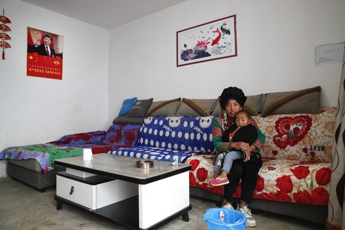 China Gusur Etnis Minoritas Demi Program Anti-Miskin A Yi woman watches new village houses decorated with colourful paintings which were built by the Chinese government for the ethnic minority members in Ganluo county, southwest China's Sichuan province on Sept. 10, 2020. China's ruling Communist Party says its initiatives have helped to lift millions of people out of poverty. Yi ethnic minority members were moved out of their mountain villages in China’s southwest and into the newly built town in an anti-poverty initiative. (AP Photo/Andy Wong)