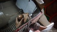 Perajin melakukan proses finishing salah satu kerajinan.