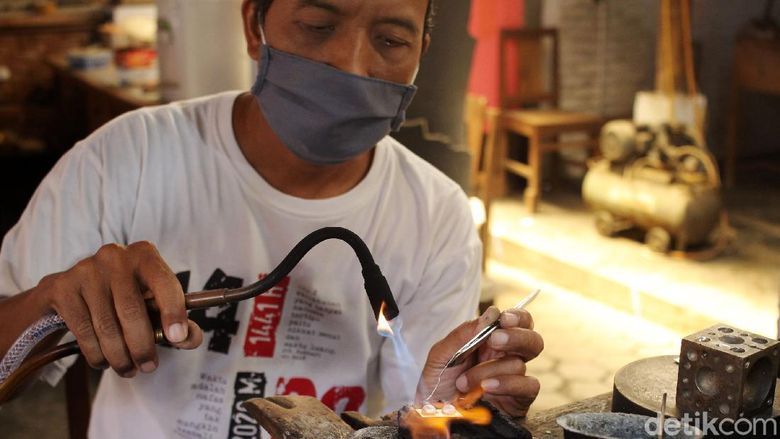 Pekerja menyelesaikan pembuatan kerajinan berbahan perak di pusat kerajinan perak Salim, Kotagede, Yogyakarta, Kamis (24/9/2020). Selama pandemi, pengrajin hanya mengerjakan produk yang dijual berdasarkan pesanan konsumen dari luar negeri.