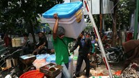 Para pedagang mengevakuasi barang dagangan mereka.