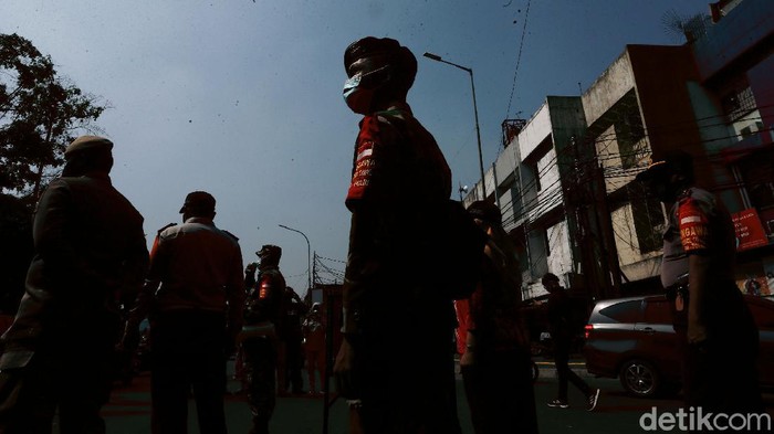 Petugas gabungan menggelar Operasi Yustisi di Terminal Kampung Melayu, Jakarta Timur, Kamis (24/09/2020). Warga yang melanggar dihukum mengecat trotoar.