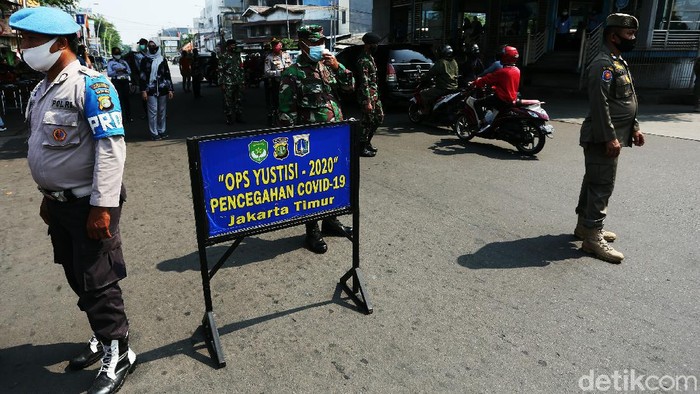 Petugas gabungan menggelar Operasi Yustisi di Terminal Kampung Melayu, Jakarta Timur, Kamis (24/09/2020). Warga yang melanggar dihukum mengecat trotoar.