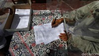 Para orang tua siswa yang telah menyerahkan lembar jawaban ujian akan didata oleh guru di sekolah tersebut.