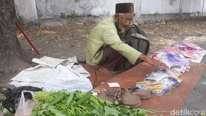 Dalimin (80) jualan kangkung, sandal dan masker di Alun-alun Kidul Keraton Kasunanan Surakarta, Jumat (25/9/2020).