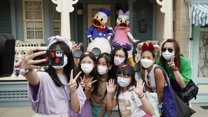 Disneyland Hong Kong kembali dibuka usai sebelumnya ditutup gegara virus Corona. Di hari pertama pembukaannya taman bermain itu diserbu pengunjung.