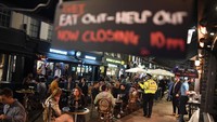 Beberapa papan tanda bertuliskan tutup jam 10 malam, dipasang di setiap kafe dan restoran.  