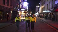 Petugas Polisi berpatroli di jalanan London saat pemberlakuan jam malam di Inggris.  