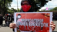 Seorang peserta membawa poster berisi tuntutan agar aparat penegak hukum mengusut tuntas kasus penusukan Syekh Ali Jaber saat melakukan safari dakwah di Lampung.