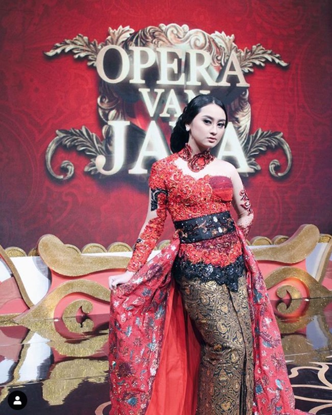 Kebaya merah modifikasi dengan ekor menjuntai menemani penampilan Memes Prameswari di Opera van Java. Dramatis! (Foto: Dok. Instagram/memes_prameswari)