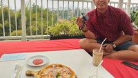 Bersantai menikmati waktu luang, Mumu pilih nongkrong di restoran dengan pemandangan alam yang indah. Lengkap dengan satu pizza yang enak. Foto: Instagram @muklis_muje
