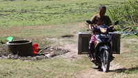 Warga terpaksa menggunakan sepeda motor karena jarak yang jauh dari rumah mereka.