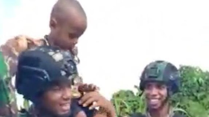 Prajurit TNI menggendong balita di Papua