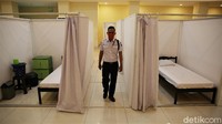 Petugas memantau kondisi di sekitar area bilik-bilik isolasi yang berada di Gelanggang Remaja Kecamatan Pademangan, Jakarta Utara. 