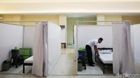 Seorang petugas sedang merapikan tempat tidur yang ada di salah satu bilik isolasi mandiri di GOR Pademangan, Jakarta Utara, Minggu (27/9/2020).