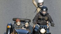 Sebuah keluarga pengendara motor mengendarai sepeda motor buatan Soviet dengan sespan selama parade. AP Photo/Alexander Zemlianichenko.