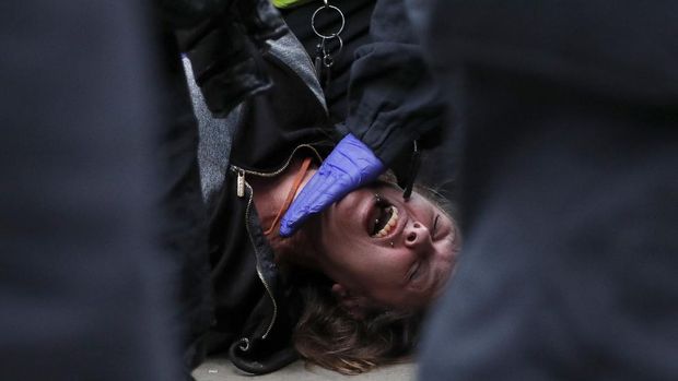 People wearing masks take part in a 'We Do Not Consent' rally at Trafalgar Square, organised by Stop New Normal, to protest against coronavirus restrictions, in London, Saturday, Sept. 26, 2020. (AP Photo/Frank Augstein)