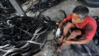 Pekerja mengupas ban bekas ukuran besar untuk dijadikan bahan baku kursi sofa di Jati, Sukoharjo, Jawa Tengah, Senin (28/9).