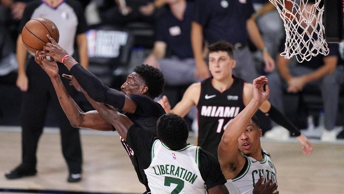 Miami Heats Bam Adebayo, left, battles for a rebound along with Boston Celtics Jaylen Brown (7) and teammate Grant Williams (12) during the second half of an NBA conference final playoff basketball game Sunday, Sept. 27, 2020, in Lake Buena Vista, Fla. (AP Photo/Mark J. Terrill)