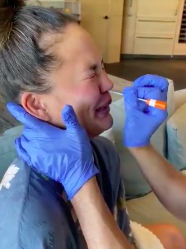 Ekspresi Chrissy Teigen saat jalani swab test.