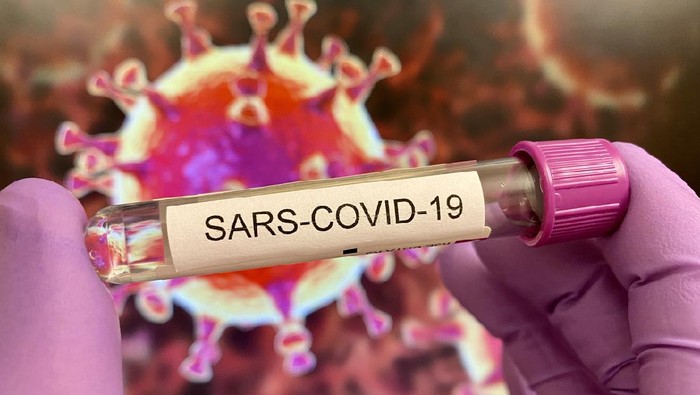ilustrasi corona Sars-CoV-19 test tube in purple protective glove, virus illustration on computer screen in background