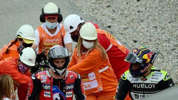 Ducatis Italian rider Andrea Dovizioso (L) and Reale Avintia Racings French rider Johann Zarco leave the track after falling down during the MotoGP race of the Moto Grand Prix de Catalunya at the Circuit de Catalunya on September 27, 2020 in Montmelo on the outskirts of Barcelona. (Photo by LLUIS GENE / AFP) / The erroneous mention[s] appearing in the metadata of this photo by LLUIS GENE has been modified in AFP systems in the following manner: [Reale Avintia Racings French rider Johann Zarco] instead of [Petronas Yamaha SRT Italian rider Franco Morbidelli]. Please immediately remove the erroneous mention[s] from all your online services and delete it (them) from your servers. If you have been authorized by AFP to distribute it (them) to third parties, please ensure that the same actions are carried out by them. Failure to promptly comply with these instructions will entail liability on your part for any continued or post notification usage. Therefore we thank you very much for all your attention and prompt action. We are sorry for the inconvenience this notification may cause and remain at your disposal for any further information you may require.