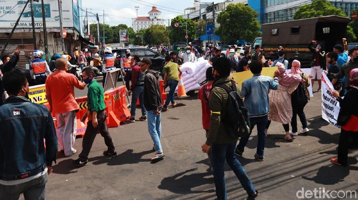 Ratusan pedagang Pasar Baru Bandung turun ke jalan dan melakukan aksi protes dengan kebijakan Pemerintah Kota (Pemkot) Bandung yang mengeluarkan kebijakan buka tutup jalan di Jalan Suniaraja-Otista. Pantauan detikcom, Senin (28/92020) water barier yang menutup jalan tersebut dibuka paksa dan dipindahkan oleh para pedagang ke pinggir jalan.