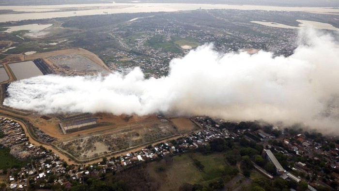 Asap Kebakaran TPA Menutupi Lingkungan Miskin di Paraguay Residents commute to work through the smoke coming from a fire at the capital city's main landfill in the poor Bañado Sur neighborhood in Asuncion, Paraguay, Monday, Sept. 28, 2020. The fire began Saturday night and it has been burning ever since without firefighters been able to put it out. (AP Photo/Jorge Saenz)