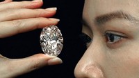 Sebuah berlian 102,39 karat, yang dikenal dengan warna D, dipamerkan oleh seorang model di rumah lelang Sotheby, Hong Kong, Senin (28/9/2020) waktu setempat.