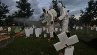 Meski ditengah pandemi COVID-19 dan semakin tingginya angka kematian akibat Corona itu, petugas menyemprotkan cairan disinfektan guna mencegah penyebaran COVID-19, di area pemakaman massal korban bencana gempa, tsunami, dan likuefaksi yang ramai dikunjungi oleh peziarah, di Palu, Sulawesi Tengah. ANTARA FOTO/Mohamad Hamzah