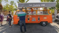 Truk makanan Issa diparkir di tepi jalan utama di kota Ramallah, Palestina saat para pekerja memanggang hot dog dan pelanggan menunggu pesanan mereka.
