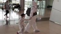 Seorang warga tampak mengenakan alat pelindung diri saat bersiap untuk menaiki pesawat di Bandara Gimpo yang berada di Seoul, Korea Selatan, jelang perayaan Chuseok. AP Photo/Lee Jin-man.