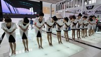 Sejumlah SPG cantik menyapa pengunjung dengan membungkukkan badan. Feng Li/Getty Images.
